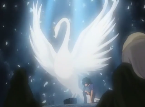 Princess Tutu, a giant, glowing white swan, stands besides Fakir as he crouches. There are white feathers falling around them, and two people in cloaks lay on the ground, looking at them.